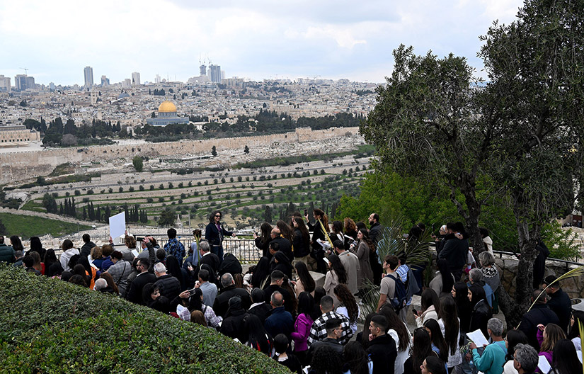 Christians waved palm and olive branches as they walked the traditional path that Jesus took on his last entry into Jerusalem during the Palm Sunday procession on the Mount of Olives in Jerusalem March 24.