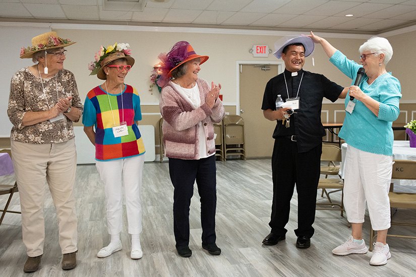 Father Steve Lian jokingly joined in the judging of a spring bonnet contest with, from left, Marion Zebas, Mary Lou Watson, Faye Byrd and Barb Cox during a Silver Saints gathering April 24 at the Knights of Columbus hall near Hillsboro. The Silver Saints gathering brought together parishioners from Our Lady in Festus, Sacred Heart in Crystal City and Good Shepherd in Hillsboro.
